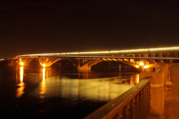 Iluminación puente reflejado en el río de noche — Foto de Stock