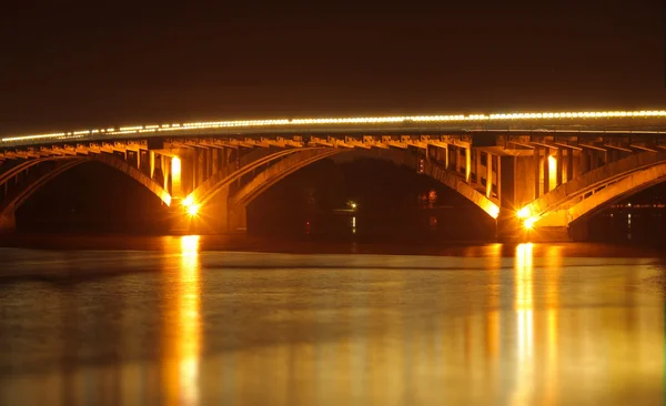 Iluminación puente reflejado en el río de noche — Foto de Stock