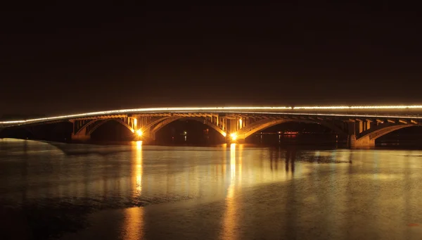 Iluminação da ponte refletida no rio noturno — Fotografia de Stock