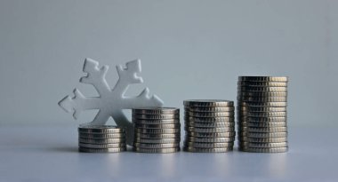 Yükselen madeni paralar bir kar tanesiyle örtüşüyor. Ticari faaliyetleri ve kâr tablolarını göstermek için stok fotoğrafı