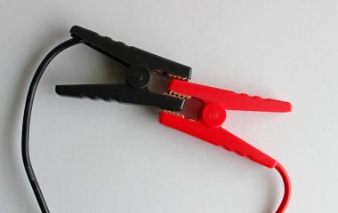 Isıya dayanıklı iki pil şarj mengenesi beyaz üzerine izole edilmiş siyah ve kırmızı kablolar.