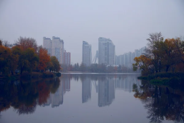 Paisaje urbano reflejado en el agua del lago — Foto de Stock