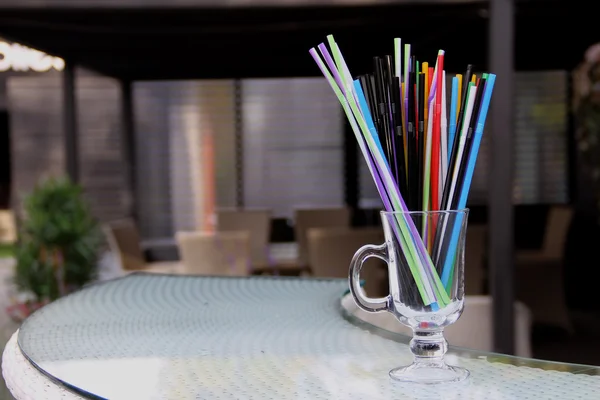 Pailles de cocktail colorées en verre clair sur le bureau du bar — Photo