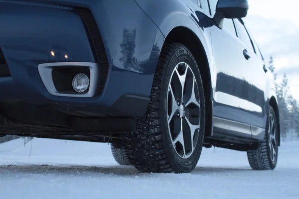 Dubbade däck på bilen på snö road — Stockfoto