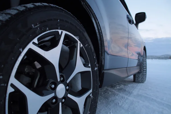 Χειμώνα κατάσπαρτος ελαστικά αυτοκινήτου στο χιόνι road — Φωτογραφία Αρχείου