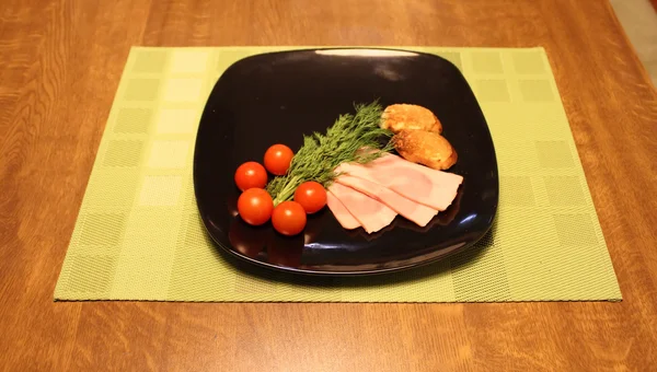 Sliced ham, cherry tomatoes and greens studio isolated — Stock Photo, Image