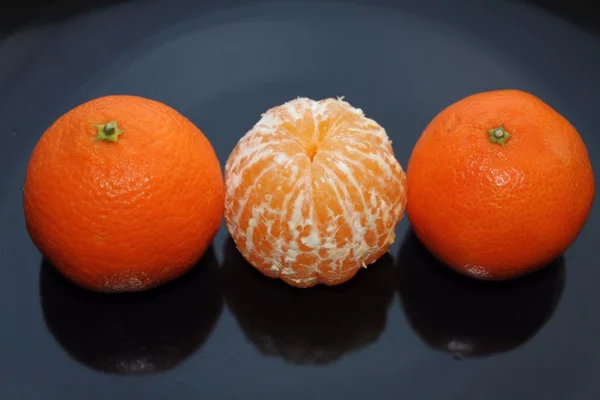 Mandarim descascado entre todo o estúdio de mandarinas isolado — Fotografia de Stock