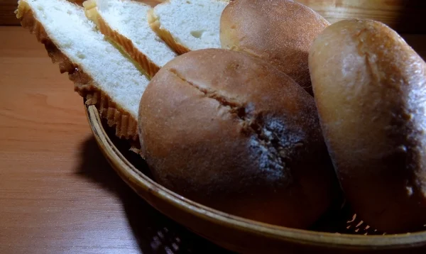 Pan rebanado y bollos deslizantes en canasta de mimbre —  Fotos de Stock