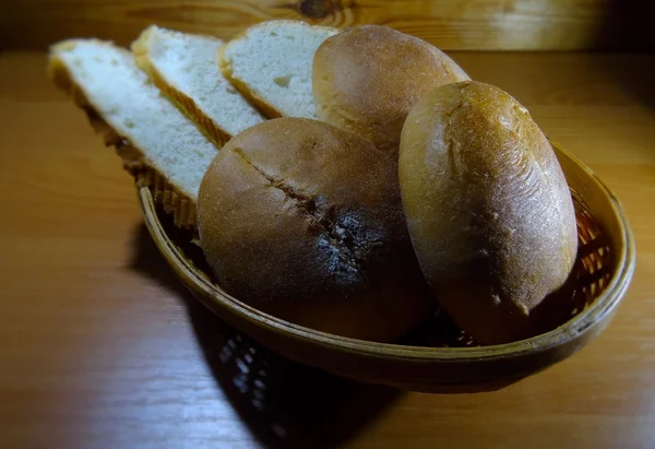 Pão fatiado e pães deslizantes em cesta de pão de vime — Fotografia de Stock