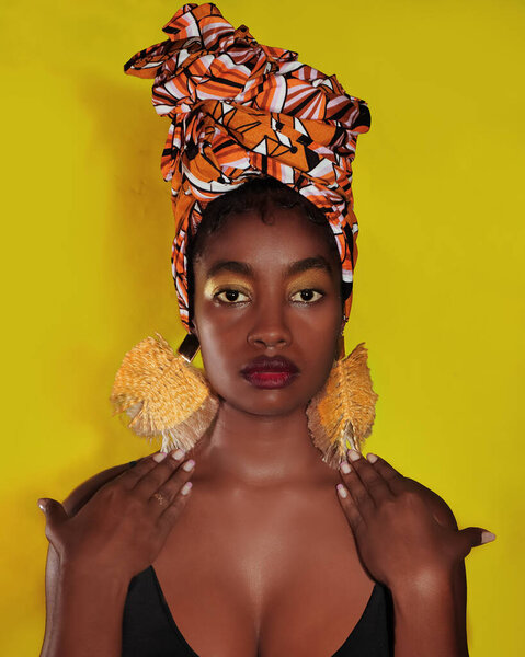 Joven Mujer afro / negra bella con turbante y aretes culturales, de perfil.