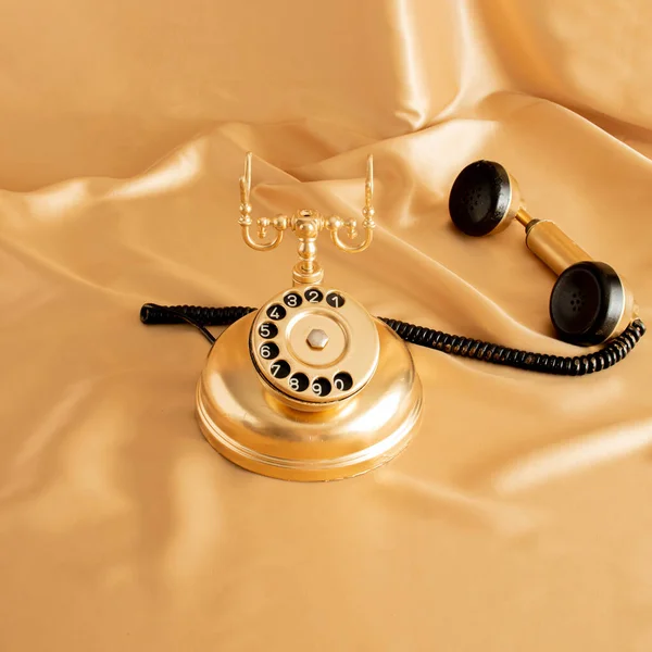 golden retro old phone on golden bright background. minimal abstract creative idea