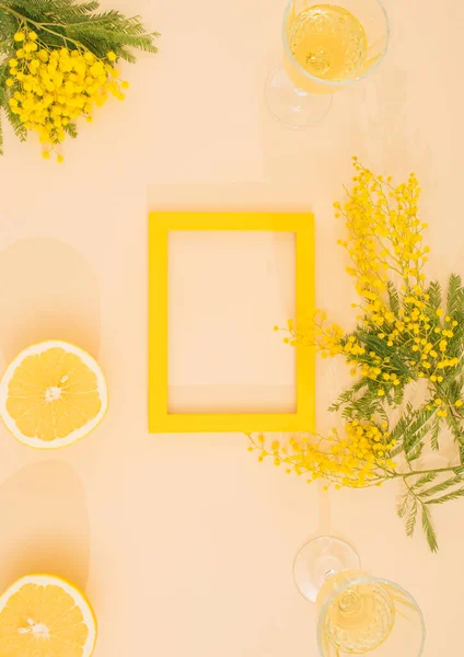 yellow mimosa on illuminating background in the picture frame. minimal flat lay background