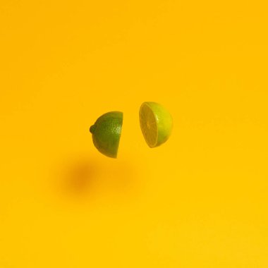 Taze tropikal yeşil kireç, sarı güneşli yaz arka planında havada uçuşuyor. Soyut sanat. asgari yaratıcı fikir.