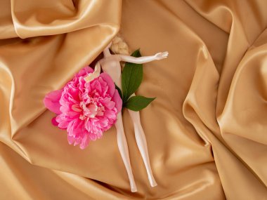 Taze pembe şakayık ve altın perdedeki oyuncak bebek. Modern yaz soyut sanatı. asgari bahçıvanlık düzlüğü tropikal arkaplan