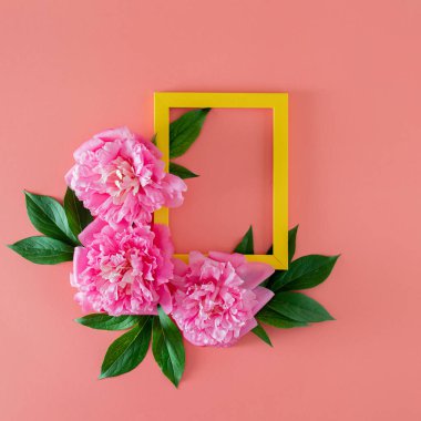 Yeşil yapraklı taze pembe şakayık ve fotokopi alanı olan pembe pastel arka planda çerçeveli. Kopyalama alanı olan asgari tropikal yaz düzlüğü. en küçük bahçe arkaplanı.