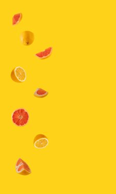 Aydınlatıcı sarı arka planda taze limon ve greyfurt. Tropik yaz soyut sanatı. en düşük düzlük