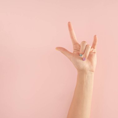 Pastel pembe arka planda renkli tırnakları olan kadın elleri. kopyalama alanı. yaz modern tropikal soyut sanat ve kadın eli. Kopyalama alanı olan en küçük arkaplan fikri