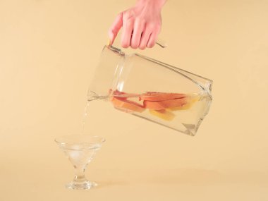 Taze greyfurt ve limon suyu sarı krem rengi pastel arka planda bir sürahi içinde. Modern tropikal soyut sanat. yaratıcı dekorasyon asgari fikir