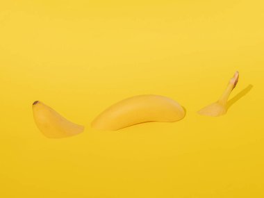 Sarı kağıtta taze sarı muz yüzer. Tropik soyut sanat. Kopyalama alanı olan minimalizm