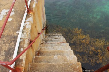 Merdivenler mavi suya iniyor.