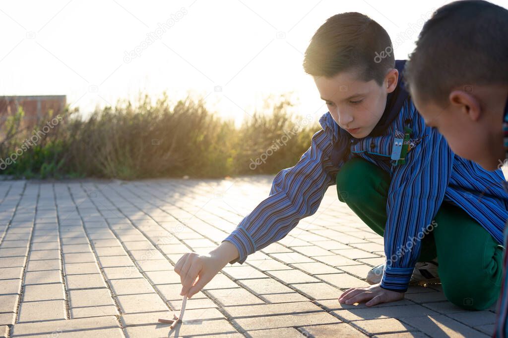 kids wearing a valencian fallas dress and playing with firecrackers