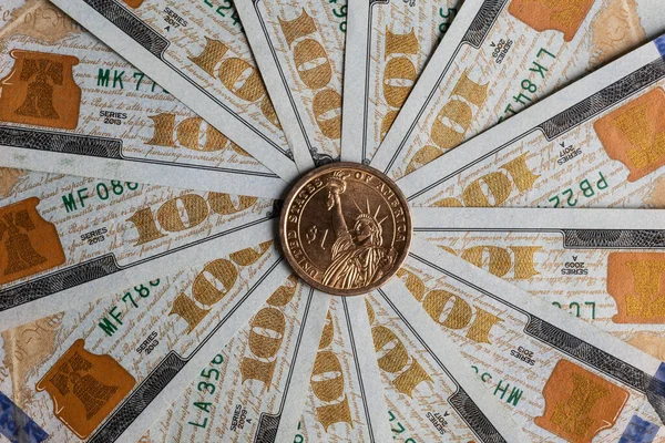 美国一美元硬币 有自由女神像的形象和一美元的象征 背景是100美元钞票的碎片 呈圆形 — 图库照片