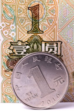 1 Yuan 'lık banknotun arka planına karşılık 1 Yuan' lık bir Çin parası.