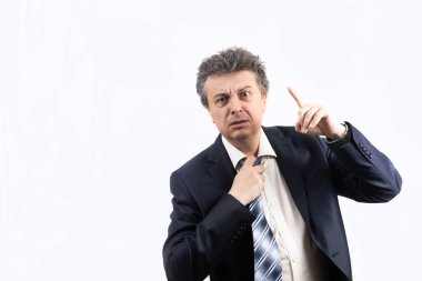 Tıraşsız, orta yaşlı, takım elbiseli, dağınık saçlı ve duygusal bakışlı bir adam. 