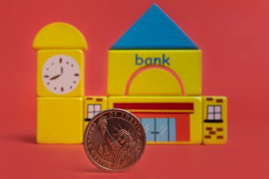 Sembolik banka binasının arka planında 1 Amerikan Doları madeni para