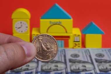 Sembolik banka binasının arka planında 1 Amerikan Doları madeni para