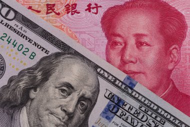 Üst üste binen 100 Çin yuanı ve 100 Amerikan doları.