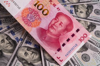 Üst üste binen 100 Çin yuanı ve 100 Amerikan doları.