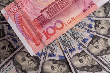 Üst üste binen 100 Çin yuanı ve 100 Amerikan doları.