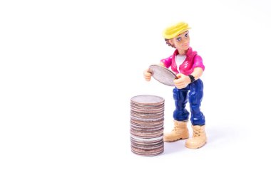 Bir adamın plastik sembolik figürü, aynı madeni paraların içinde 25 Amerikan senti değerinde bir madeni parayı beyaz bir fona karşı rapor eder.