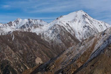 Resimli dağ zirveleri ilk karla hafifçe örtülmüş.