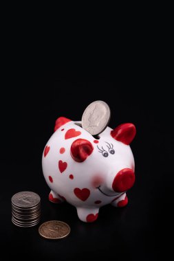 Komik domuz kumbarası ve siyah arka planda Amerikan paraları.