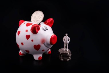 Komik domuz kumbarası ve siyah arka planda Amerikan paraları.