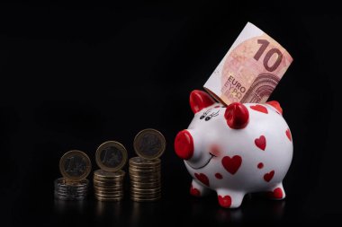 10 avroluk banknotu ve Avrupa sikkeleri olan komik bir kumbara.