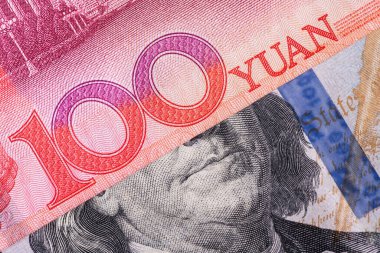 Üst üste binen 100 Çin yuanı ve 100 Amerikan doları.