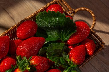 Küçük bir sepette büyük olgun kırmızı çilekler.