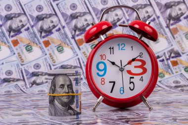 Kırmızı klasik çalar saat ve 100 Amerikan doları.