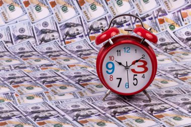 Kırmızı klasik çalar saat ve 100 Amerikan doları.