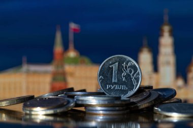 Moskova Kremlin 'in sembolik, odak dışı parçalarının önünde duran bir yığın başka madeni paraya 1 Rus rublesi.