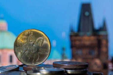 Prag binalarının odak dışı parçalarının arka planına karşı 20 CZK madeni para ve diğer madeni paralar