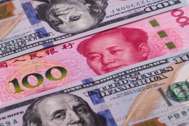 Üst üste binen 100 Çin yuanı ve 100 Amerikan doları.