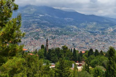 Minare ve caminin kubbesi, Türkiye 'nin Alanya tatil beldesinin eski ilçesinin arka planına karşı..