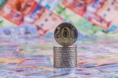 Kazakistan banknotlarının arka planına karşılık 200 Kazakistan madeni parası.
