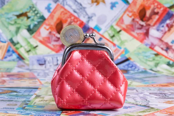 Kazakistan banknotlarının arka planında 100 adet Kazakistan kadrosu ve minyatür kırmızı cüzdan var.