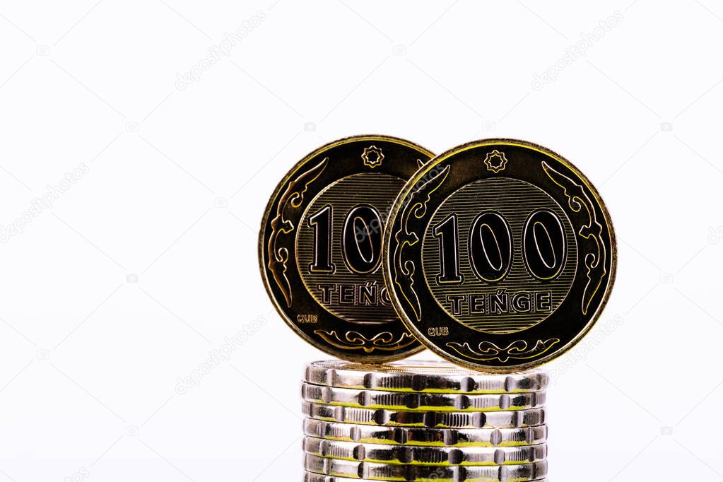 Coins in denominations of 100 Kazakhstani tenge on a white background