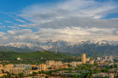 Almaty şehrinin merkezi havadan görünüşü ile Zailiyskiy Alatau dağlarının arka planı karşı karşıya. 